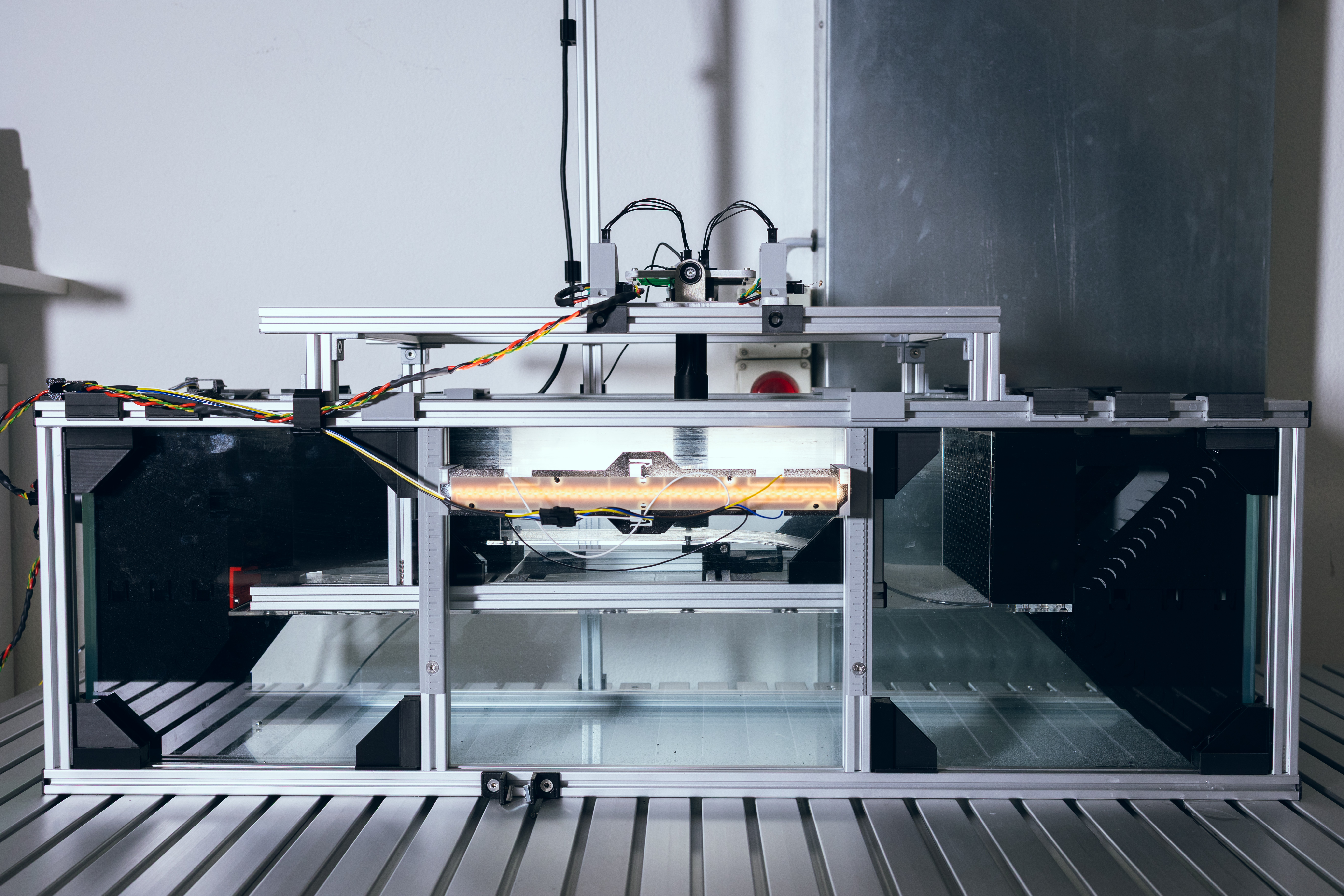 V1 front view in ambient light showing aluminium extrusion frame and transparent test section